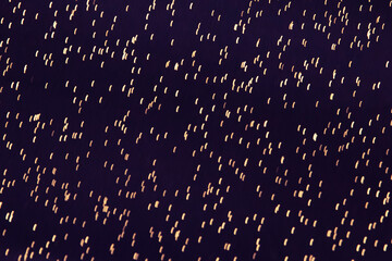 Abstract Dots on Dark Background. Dark purple background with gold dots. Fabric texture with shiny...