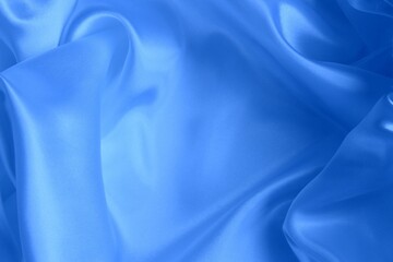 Blue satin background. Silk fabric with pleats. Satin, silk or satin create a beautiful drapery. Fashionable design.