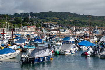 Obraz premium Boats in The Cobb harbour. Located in the seaside town Lyme Regis which is in west Dorset, southern England