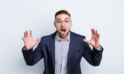 Fototapeta premium young handsome man screaming with hands up in the air. businessman concept