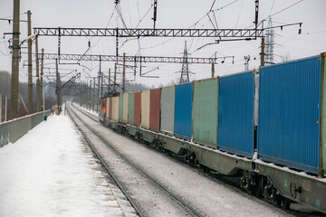 The container train transports goods in the winter. In perspective. Logistic concept.