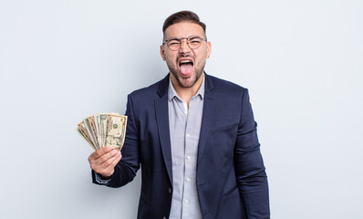 young handsome man with cheerful and rebellious attitude, joking and sticking tongue out. dollar...