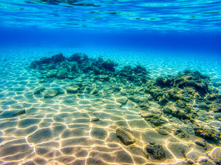 Fototapeta na wymiar Red Sea bottom covered with golden sand and rocks near coast of Egypt.