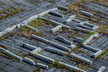Urban industrial background of a labyrinth laid on an old mossy limestone floor with copy space