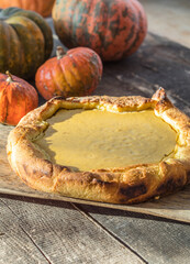 Traditional American pumpkin pie with whipped cream and cinnamon on dark table. top view