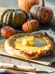 Traditional American pumpkin pie with whipped cream and cinnamon on dark table. top view