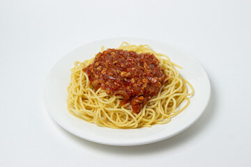 Spaghetti with meat gravy on a white plate. Traditional cooking