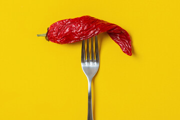 Twisted and dried red pepper on a fork, spicy food