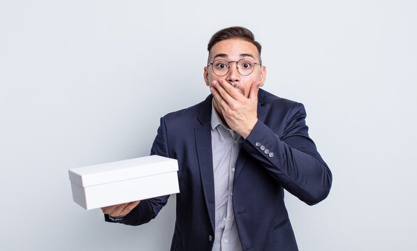 young handsome man covering mouth with hands with a shocked. white box concept