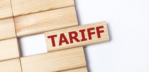 On a light background, wooden blocks with the text TARIFF. Close-up top view.
