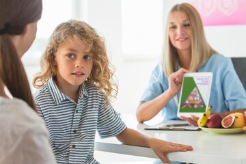 Friendly dietitian explaining the basics of healthy nutrition to a young boy