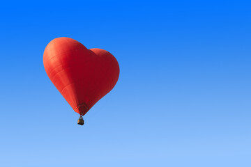 Fototapeta na wymiar Red heart shaped balloon on blue background