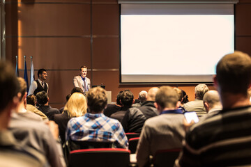 Business speaker giving a talk at business conference meeting event.