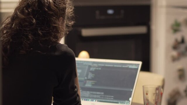 Young IT developer woman coding on her laptop, working remotely, working from home consept during the pandemic
