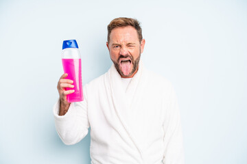 middle age man with cheerful and rebellious attitude, joking and sticking tongue out. shampoo bottle