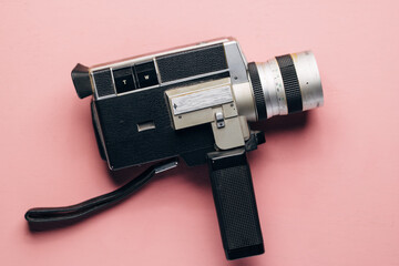 Vintage super 8 camera on a pink background. Concept of vlogging. Retro camera, feminine blogger....