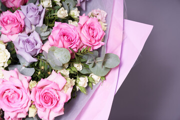 A large colorful bouquet of flowers. Large pink roses and eucalyptus leaves. On a light background, side view. The concept of the holiday. High quality photo