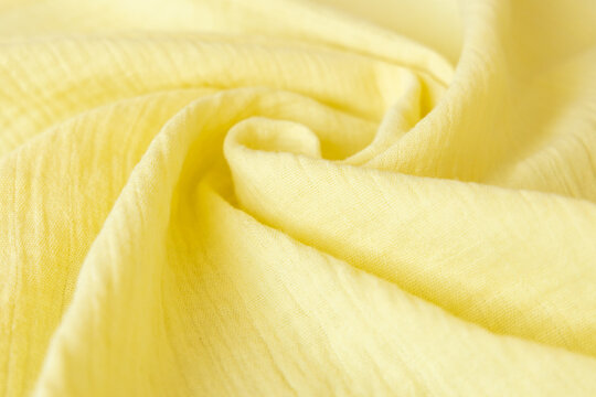 Soft Muslin Baby Blanket Background. Cotton Clothing And Textiles. Natural Organic Fabrics Texture. Light Yellow, Lemon Color. Close Up.
