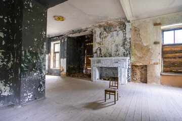 Chair in the loft-style room, fireplace in the background, shabby walls. High quality photo