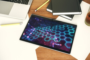 Top view of modern digital tablet monitor with technology hologram with hexagon. Research and development software concept. 3D Rendering