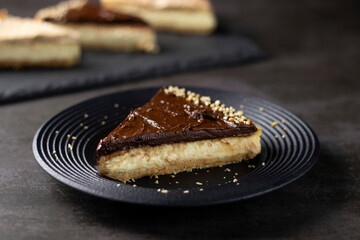 Chocolate Cheesecake with walnuts on black plate