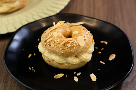 Traditional and classic dessert Paris Brest on black plate