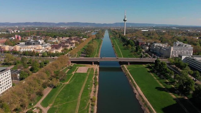 Top view of the embankment of the Neckar River. Bridges, TV tower, green grass and trees. Hospital, tram lines. Mannheim. Germany.