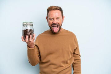 middle age man with cheerful and rebellious attitude, joking and sticking tongue out. coffee beans...