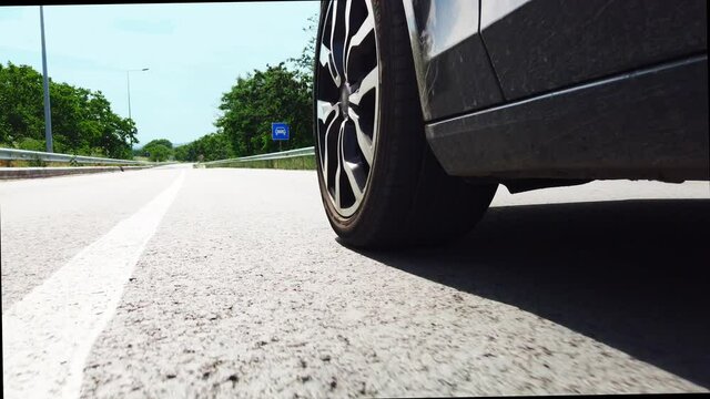 Low rear view of sports car tires speeding fast on the empty highway