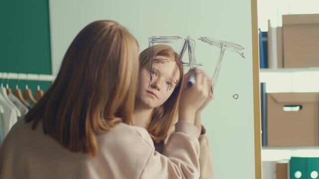 Reflection of a Red haired Teenage Girl Writing an Inscription on a Mirror, Suffering from Anorexia, Bulimia, Eating Disorder. Mental Health.