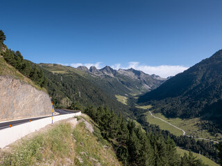 Fototapeta na wymiar asphalt road and hiking trail entering into a mountain valley