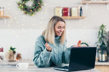 Business woman working at home on laptop during Christmas and New Year, happy and successful making a video call to colleagues and friends