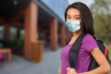 student after covid with a backpack and a medical mask goes to school university after being vaccinated