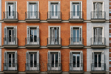 Fototapeta na wymiar Elevation View of Old Luxury Residential Building with Brick Facade and Balconies