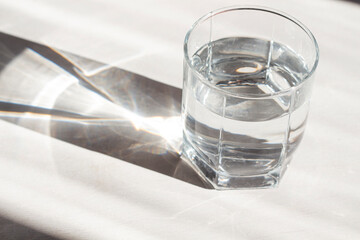 Glass of water in sunlight on the table