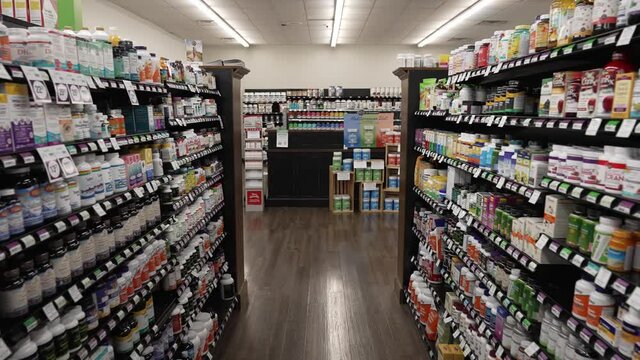 Moving down a store aisle with supplements and vitamins in a health foods market