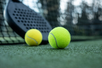 Paddle tennis rackets and balls on artificial grass
