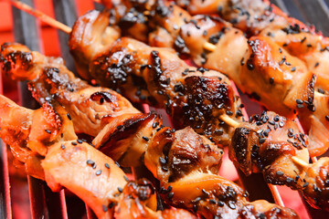 Tasty chicken skewers cooking on grill