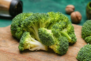 Board with healthy broccoli cabbage on color background