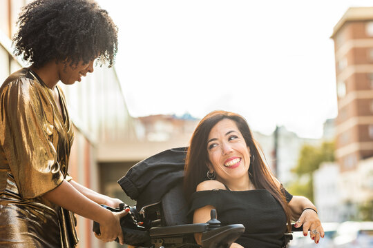 Handicapped Hispanic Woman On A Motor Wheelchair Celebrate New Year Eve Party With Friends