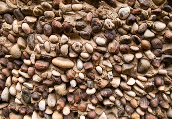 Yellow orange warm pebble stone wall abstract background texture.