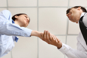 Obraz premium Businesswoman shaking man's hand in office, closeup