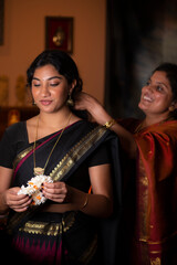 Mother fixing daughter's hair 