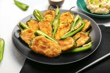 Plate with delicious jalapeno poppers on light background, closeup