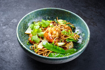 Modern Style traditionell gebratenes Thai Phak Kung mit Riesengarnelen, Gemüse und Nudeln serviert in einer Nordic Design Schale