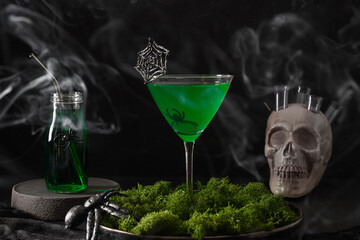 Halloween green cocktails with skulls, spiders and smoke on black background. Horror funny food .