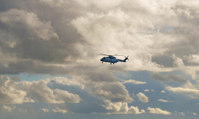 Fototapeta na wymiar British Royal Navy AgustaWestland Merlin HM.2 AW101 helicopter on a military exercise over Wiltshire UK, white cloud sky