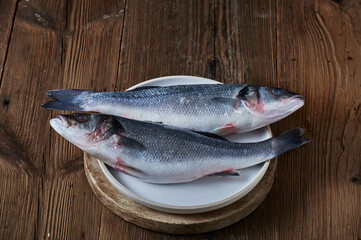 Fresh raw fish seabass on ristic wooden background