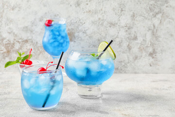Glasses of Blue Lagoon cocktail on light background