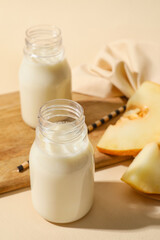 Bottles of tasty melon milkshake on color background, closeup